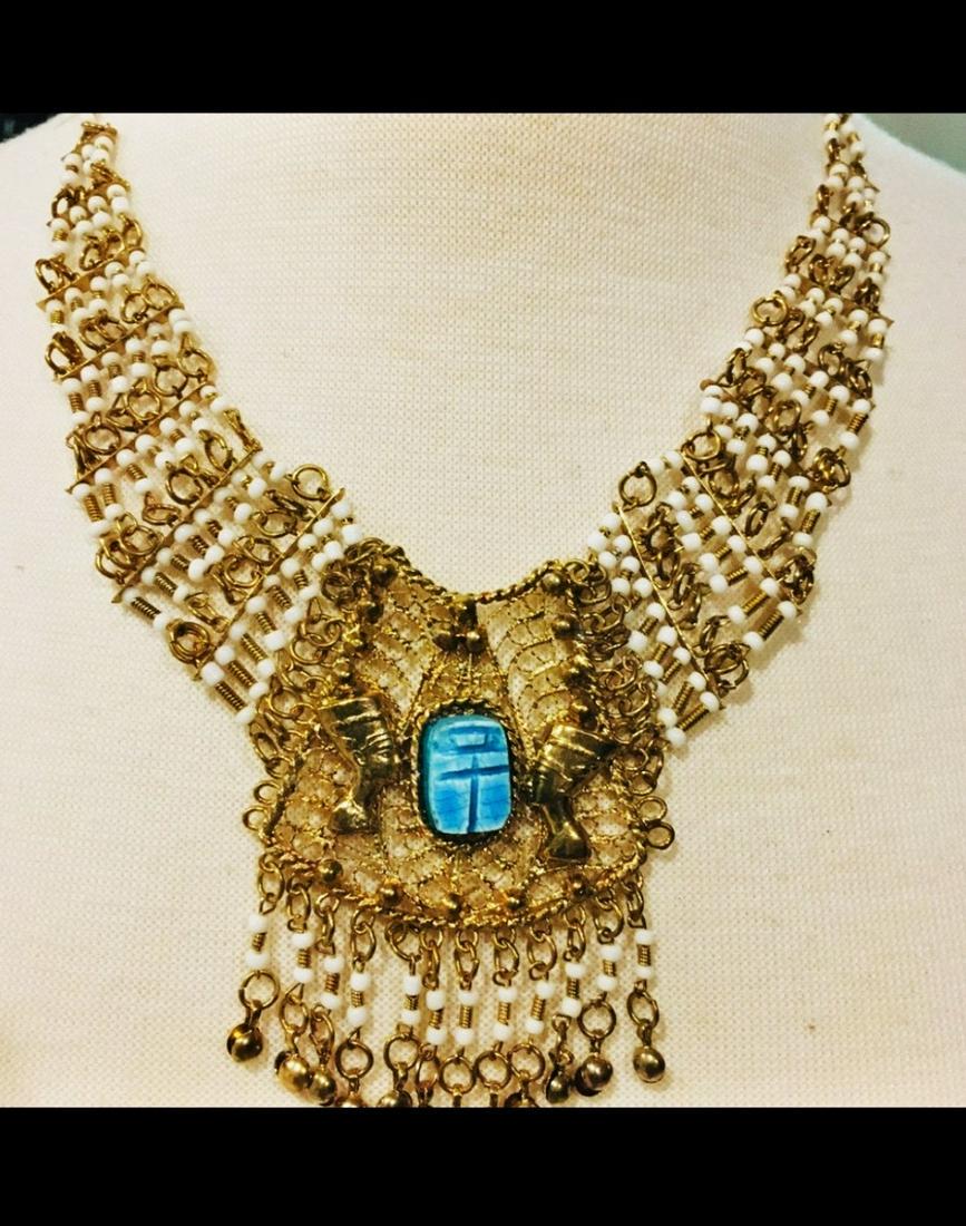 Vtg 1940's Egyptian Revival Filigree Necklace with Blue Scarab: Vintage from the 1940s Pendant width: 2.5 Inches; Pendant height: 3 Inches; Necklace length: 21 Inches Materials: Metal, Gold Plate, Scarab, Celluloid Beads, Necklace Style: Gothic Description Magnifi