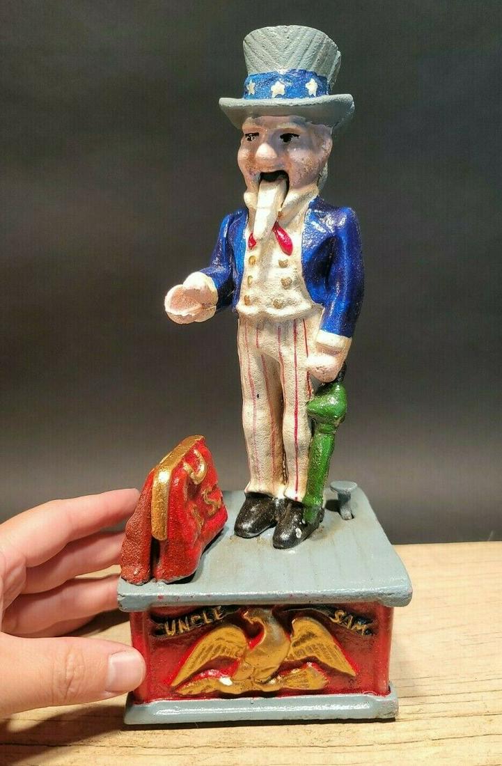 Cast Iron Uncle Sam Mechanical Coin Bank: 11" Tall 4 1/2" Wide Great reproduction Americana folk art cast iron mechanical coin bank. This piece was made to look just like an antique, but is actually new. By pressing the lever on the back the 