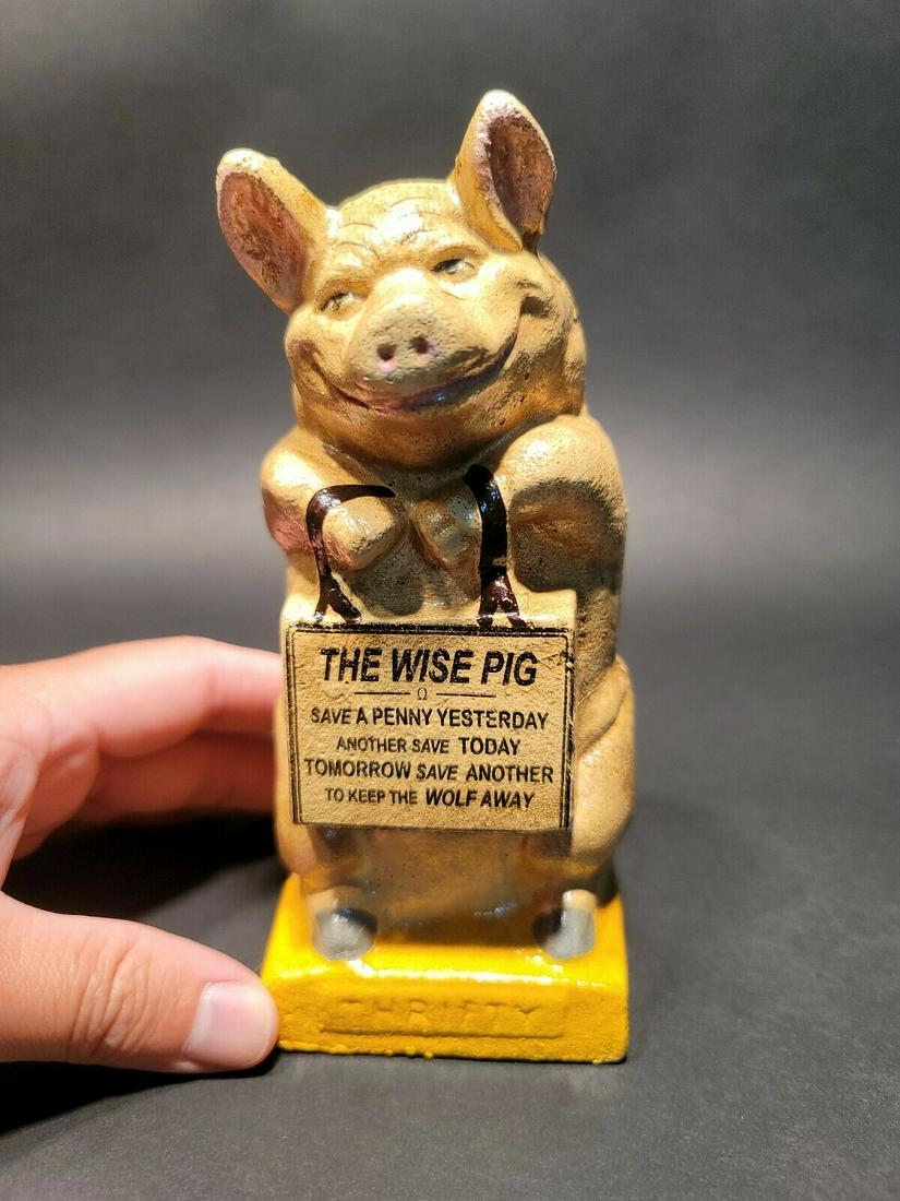 Cast Iron Thrifty Coin Bank The Wise Pig: 6 1/2" Tall x 2 3/4" wide Wonderful cast iron reproduction antique Thrifty pig coin bank doll. As you can see this coin bank looks like an original! See the images for the best details. Such a neat co