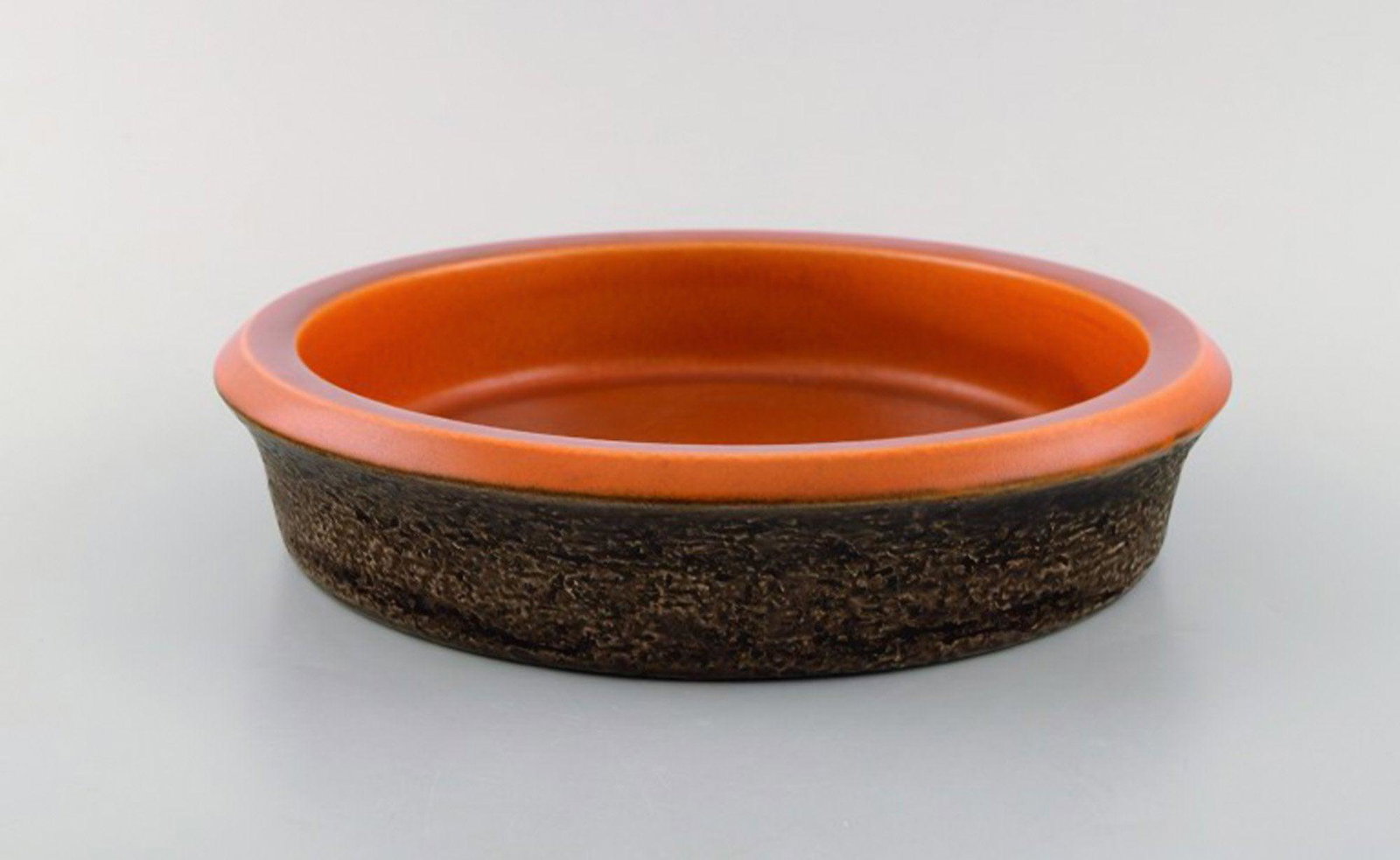 Mari Simmulson for Upsala-Ekeby. Dish in glazed stoneware. Glaze in brown and orange shades. 1960's.: Mari Simmulson for Upsala-Ekeby. Dish in glazed stoneware. Glaze in brown and orange shades. 1960's. In very good condition. Two minor glaze defects on the rim. Measures: 23 x 5 cm Stamped. Reserve: $