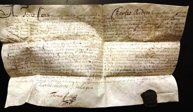 1713 Vellum Guernsey Deed and Seal: Handwritten Vellum deed from Guernsey dated 1713 during the reign of Anne naming Charles Andros as the seller. Nicely penned in French with the black seal of Guernsey attached. Fine condition, a few l