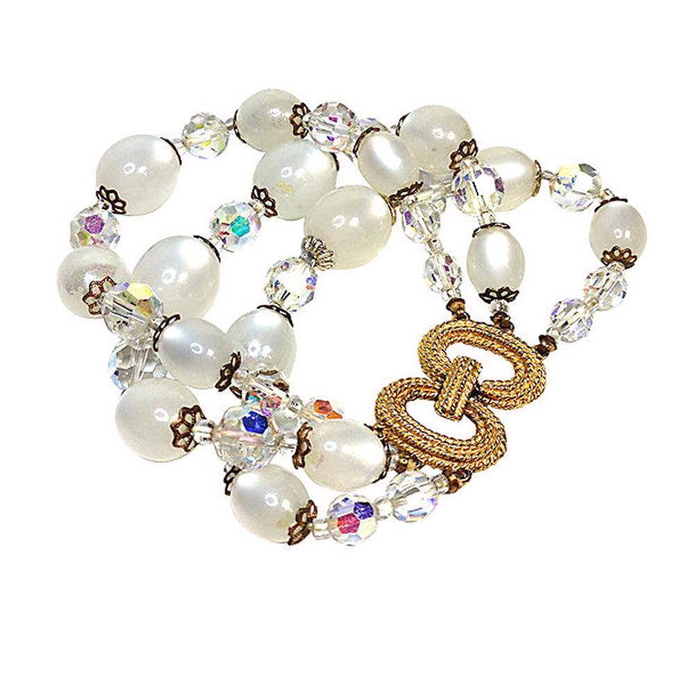 Marvella Moonstone Bracelet: 1950s Marvella goldtone fold-over clasp bracelet with faceted aurora borealis crystal beads and simulated moonstone beads. Dimensions: 7.88 x 1.5 x 0.5 inch Reserve: $35.00 Shipping: Domestic: Flat-ra