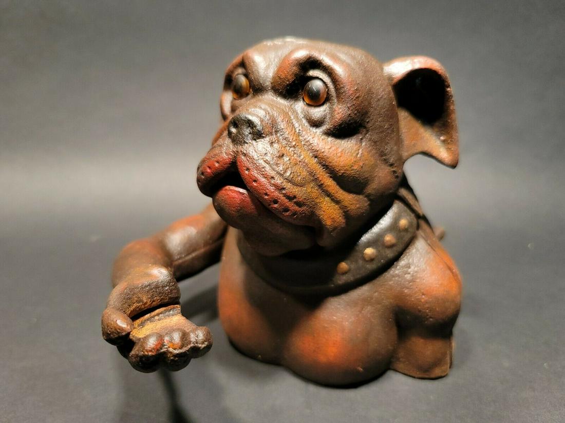 Cast Iron Bulldog Mechanical Dog Coin Bank John Harper 1915: 7" Tall 6" Wide Great reproduction folk art cast iron mechanical coin bank. This piece was made to look just like an antique, but is actually new. By pressin the lever on the back the arm will lift an