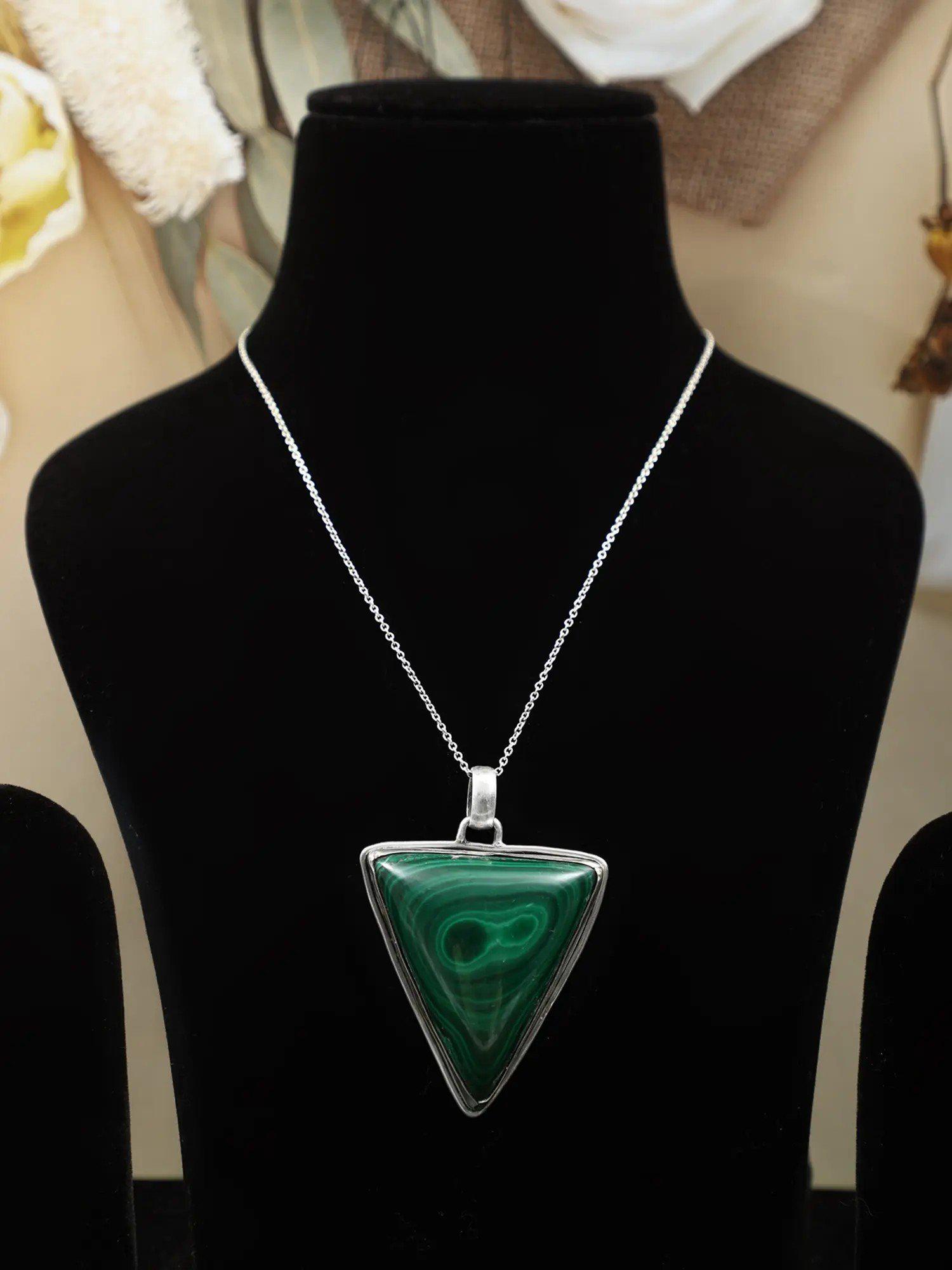 Triangle Green Malachite Pendant: Title: Triangle Green Malachite Pendant Subtitle: 2 inch Height x 1.75 inch Width x 0.45 inch Depth Additional Information: The inverted triangle in Hinduism and Tantra cult represents the unimaginabl