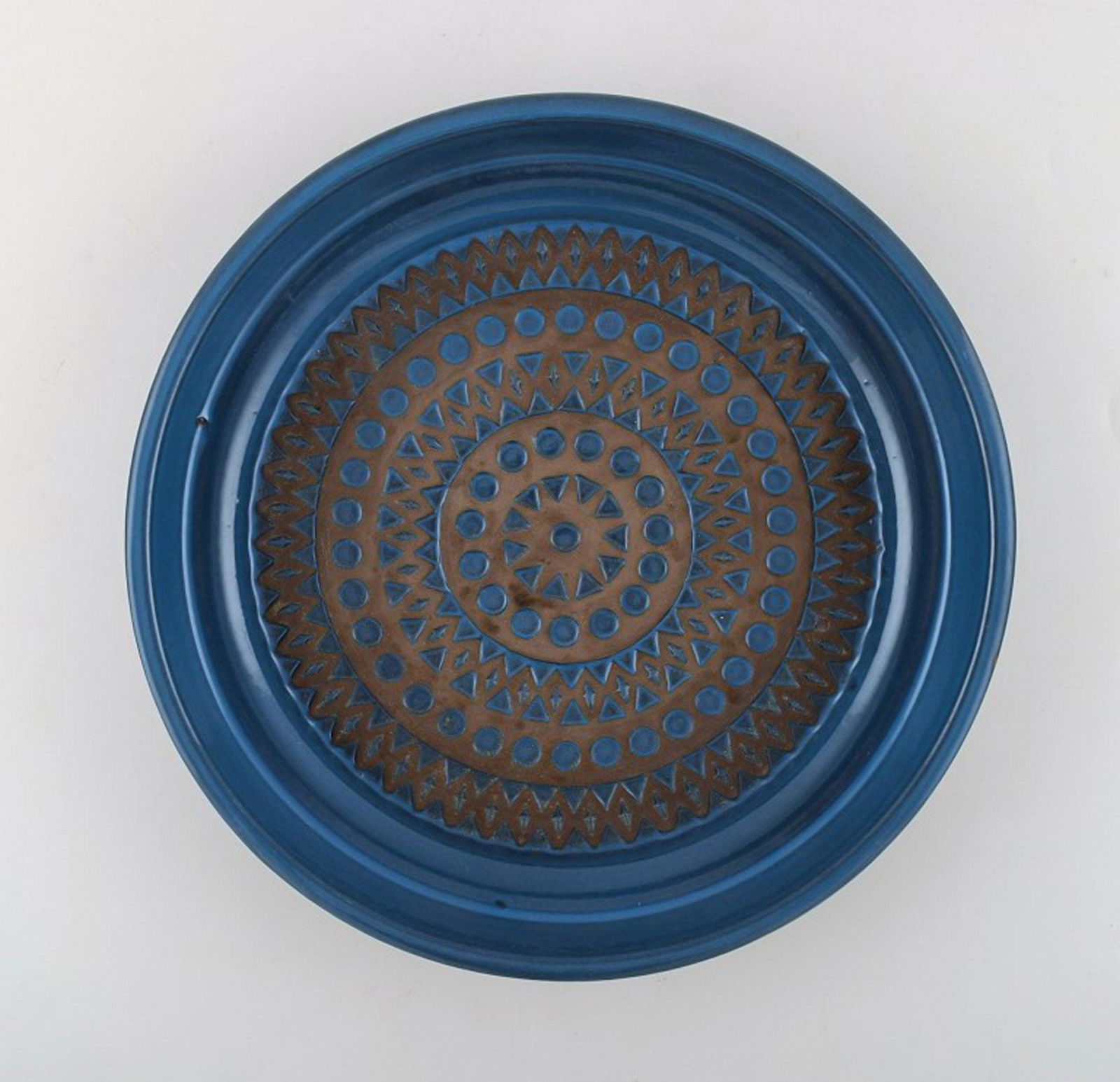 Mari Simmulson for Upsala-Ekeby. Dish in glazed stoneware with geometric pattern. Beautiful glaze in: Mari Simmulson for Upsala-Ekeby. Dish in glazed stoneware with geometric pattern. Beautiful glaze in brown and blue shades. 1960's. In very good condition. Measures: 26.5 x 4.5 cm Stamped. Reserve: $1