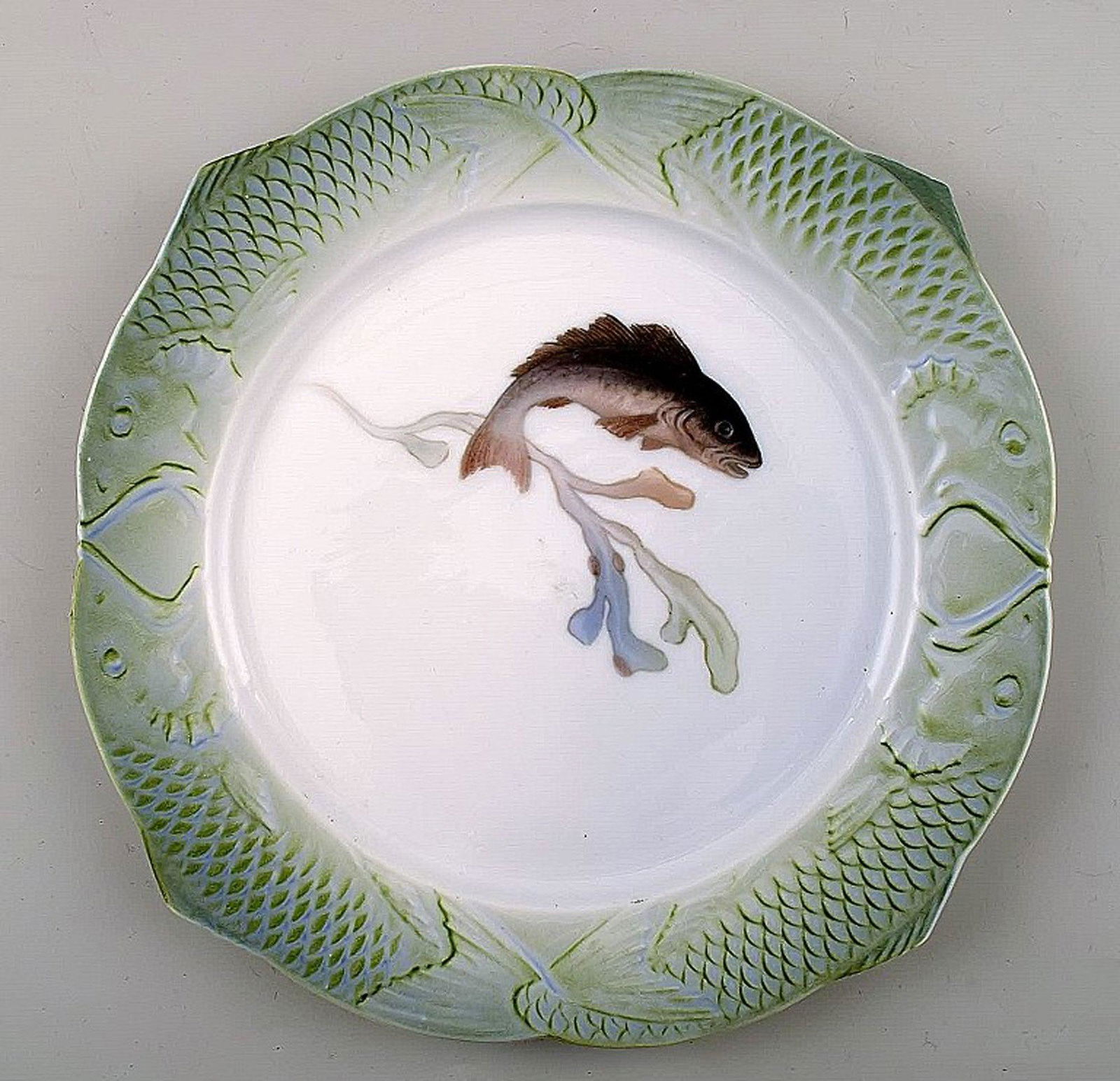 Arnold Krog for Royal Copenhagen: "Fish service" dinner plate in porcelain, decorated in colors with: Arnold Krog for Royal Copenhagen: "Fish service" dinner plate in porcelain, decorated in colors with a fish. Number 1/3002. Measures: 25 cm. 1st. factory quality, in perfect condition. Reserve: $210.0