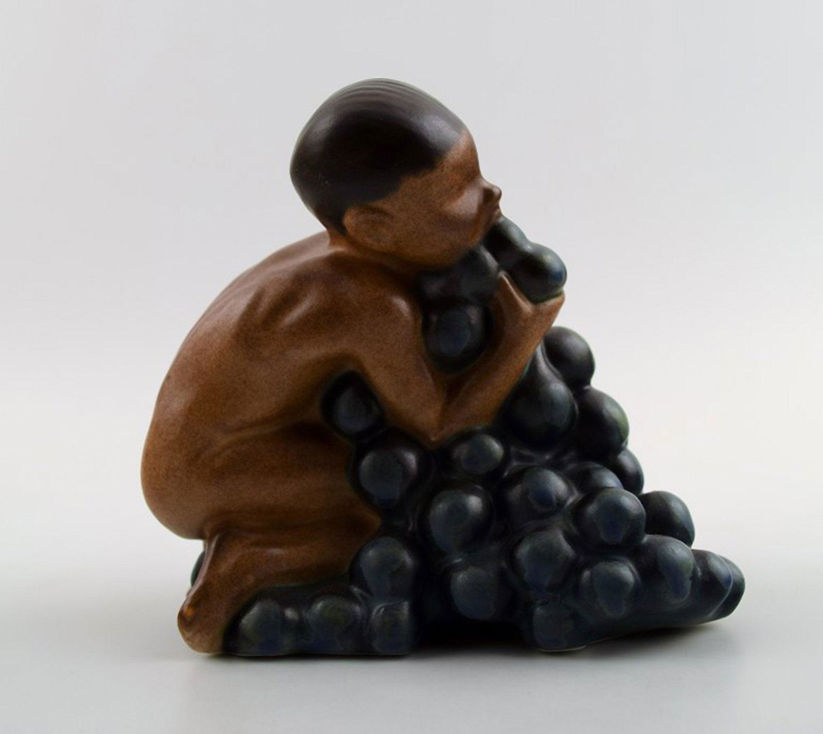 Bing & Grondahl, stoneware figurine of boy with bunch of grapes by Kai Nielsen. Model number 4021.: Bing & Grondahl, stoneware figurine of boy with bunch of grapes by Kai Nielsen. Model number 4021. From the series 'Grape Harvesting'. Measures 10.5 cm. x 9.5 cm. 1. Quality, in perfect condition. Res