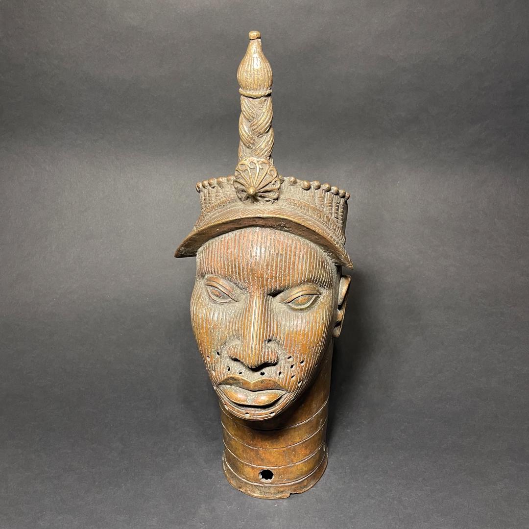 Benin Kingdom Bronze Head: Title: Benin Kingdom Bronze Head Date/Period: 19th Century Materials/Origin: Nigeria, Africa Dimension: 22in x 7.5in x 10in Reserve: $600.00 Shipping: Domestic: Flat-rate of $60.00 to anywhere within 