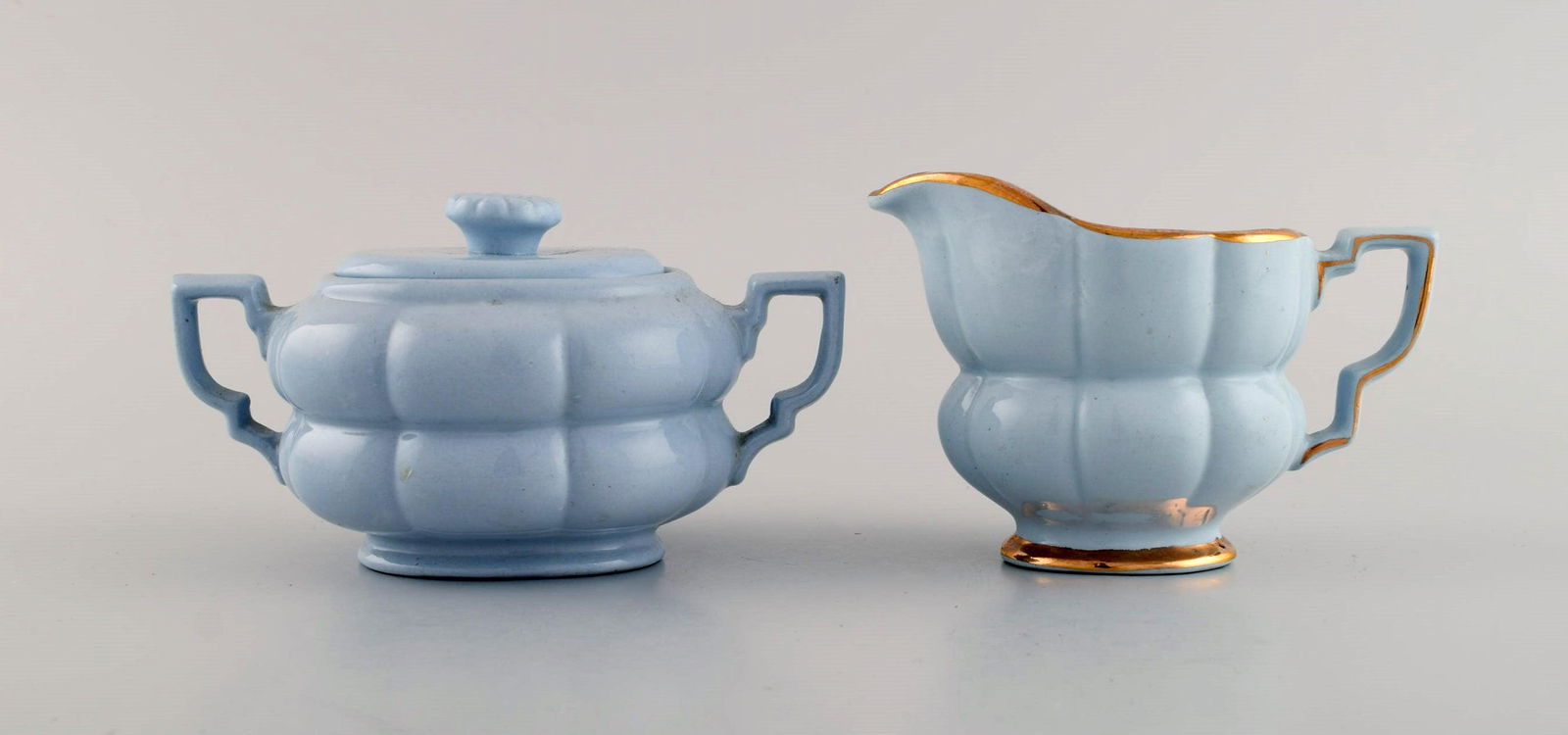 Arthur Percy for Upsala-Ekeby / Gefle. Art deco Grand sugar bowl and creamer in pastel blue: Arthur Percy for Upsala-Ekeby / Gefle. Art deco Grand sugar bowl and creamer in pastel blue porcelain with hand-painted gold edge. 1930s / 40s. The sugar bowl measures: 15 x 8.5 cm. In excellent condi