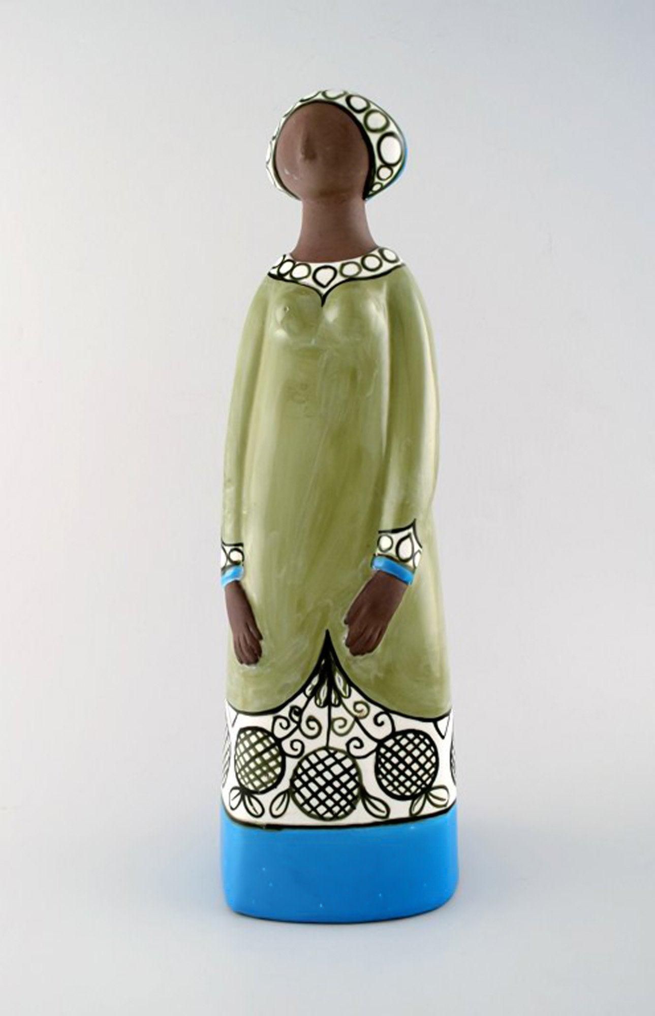 Rare MARI SIMMULSON figure of woman, ceramics, Upsala-Ekeby.: Rare MARI SIMMULSON figure of woman, ceramics, Upsala-Ekeby. Height 42 cm. Width 12.5 cm. In perfect condition. Stamped. Reserve: $938.00 Shipping: Domestic: Shipping rates are determined by destinati