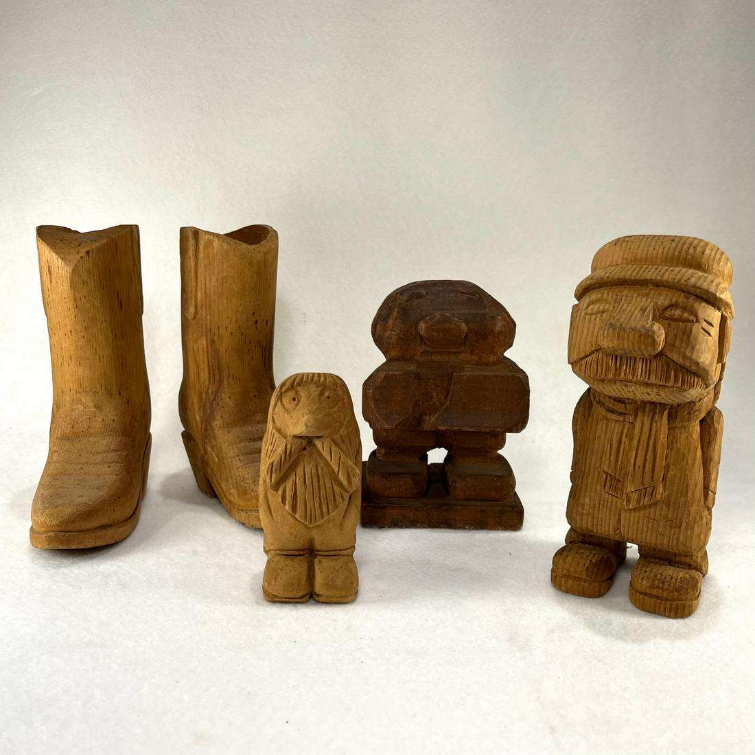 LOT OF 5 FOLK ART, PINE WOOD CARVINGS: Circa 1960s lot of 5 pine wood carvings. Tallest carvings are the pair of cowboy boots at a height of 6-3/8”. Original, dry, unfinished surface. Condition: occasional dings, scuffs, foxing spots