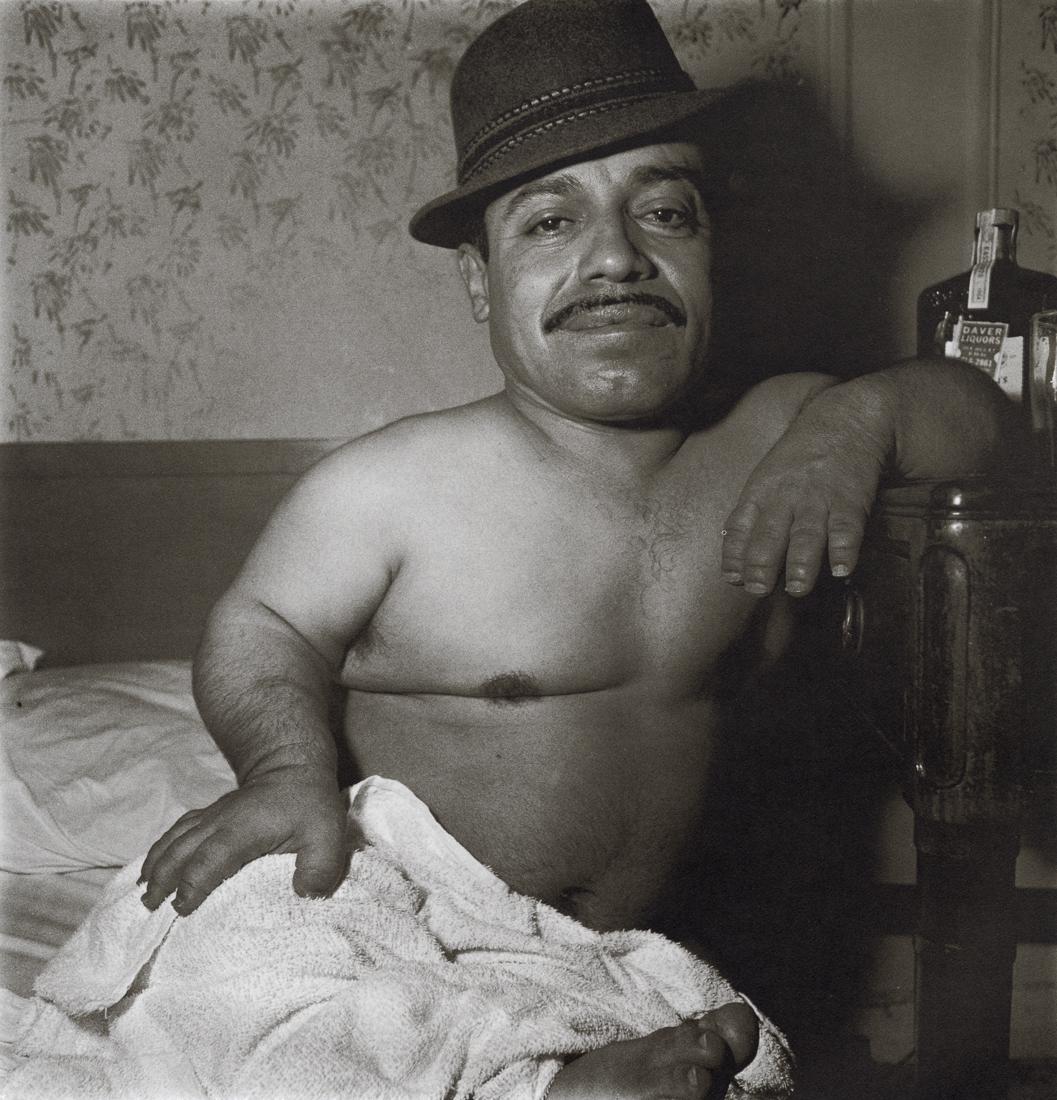 DIANE ARBUS - Mexican Dwarf In His Hotel Room, 1970: Artist: Diane Arbus Title: Mexican Dwarf In His Hotel Room In NYC, 1970 Medium: Photo Litho, 1972, USA Dimensions: 8.4x8.7" Description: Heat Wax Mounted on 11x14" Conservation Board Artist Bio: Diane