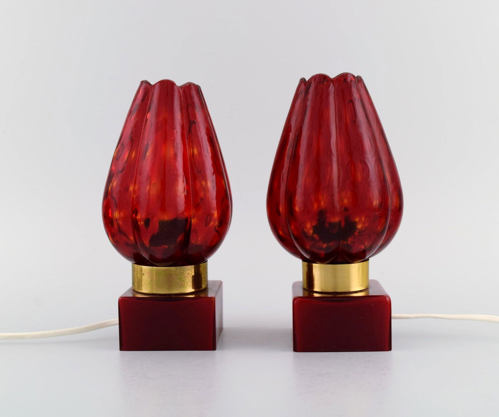 Hans Agne Jakobsson for A / B Markaryd. A pair of table lamps in brass and red mouth-blown art glass: Hans Agne Jakobsson for A / B Markaryd. A pair of table lamps in brass and red mouth-blown art glass shaped like flower petals. Swedish design, 1960s / 70s. Measures: 20 x 10 cm. In excellent conditio