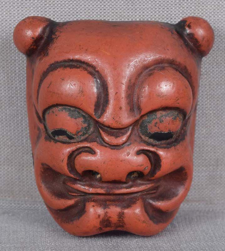 19c netsuke demon ONI MASK: 19th century lacquered netsuke representing a Noh theater mask of an oni (mischievous demon). Nice quality work, excellent expressive face, well done lacquering, pleasant patina. Height 1 9/16 inches.