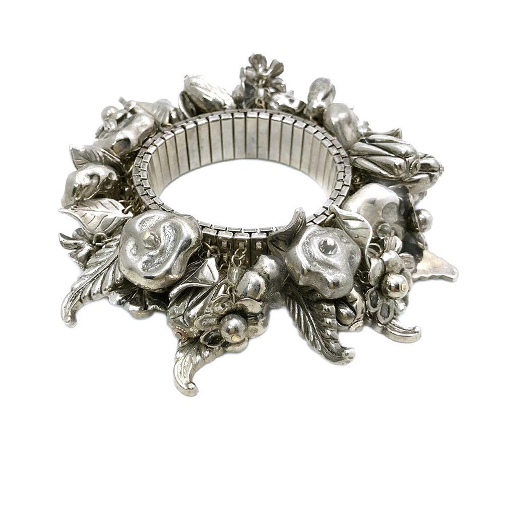 Silver Expandable Charm Bracelet: This is a 1960s silver tone metal expandable bracelet full of dangling flowers and leaf charms. Dimensions: 4 x 4 x 1.5 inch Reserve: $49.00 Shipping: Domestic: Flat-rate of $14.00 to anywhere within 