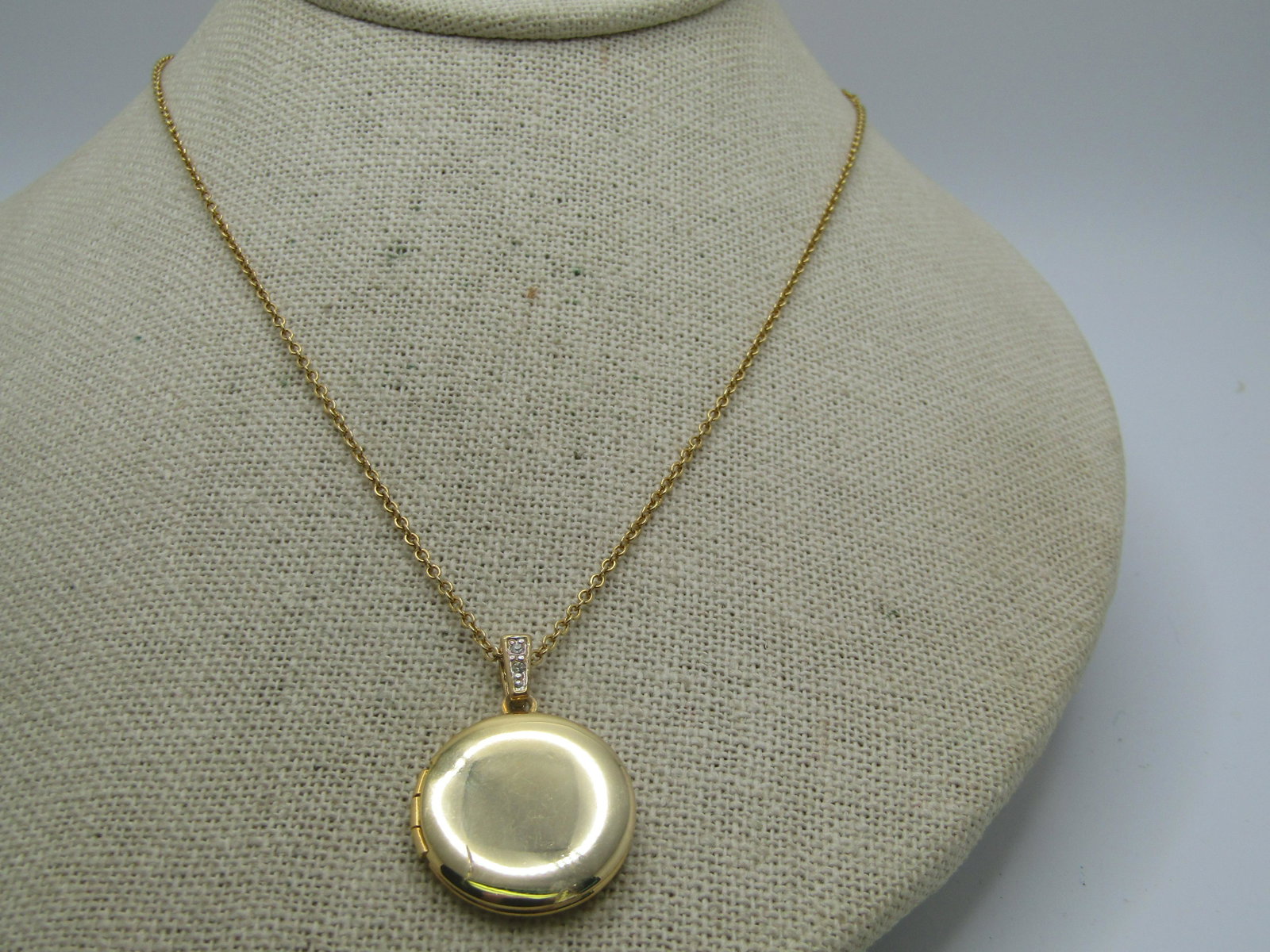 Vintage Gold Tone Locket Necklace, 18" Rhinestone Bail, 1960's-1970's: Vintage Gold Tone Locket Necklace, 18" Rhinestone Bail, 1960's-1970's. Gold tone. Pendant is1.25" tall including the bail. The bail has rhinestones on the front and is smooth on the back. The locket i