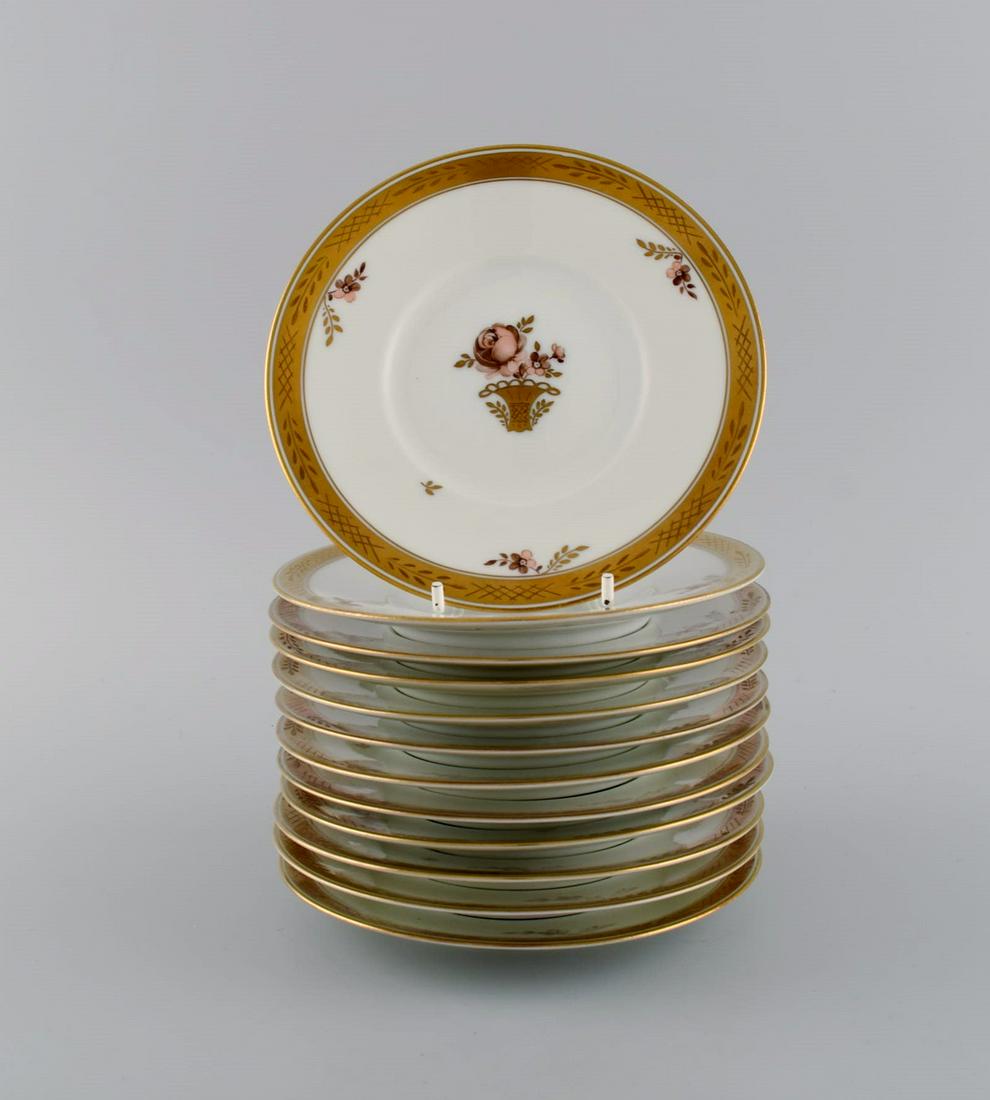 Twelve Royal Copenhagen Golden Basket cake plates in hand-painted porcelain with flowers and gold: Twelve Royal Copenhagen Golden Basket cake plates in hand-painted porcelain with flowers and gold decoration. 1930s. Model number 595/10522. Diameter: 15.6 cm. In excellent condition. Stamped. 1st fac