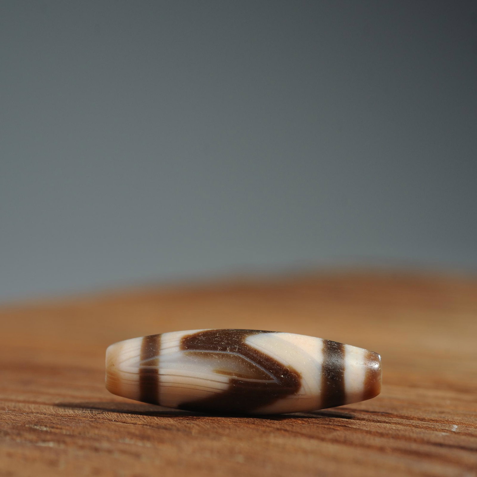 Tibetan tiger tooth agate dzi bead: Title: Tibetan tiger tooth agate dzi bead Origin: Asian private collection Date: 19th C Description: Size: Beads about 40x13mm Tibetan antique agate dzi bead. Agate beads have circular horseshoe print