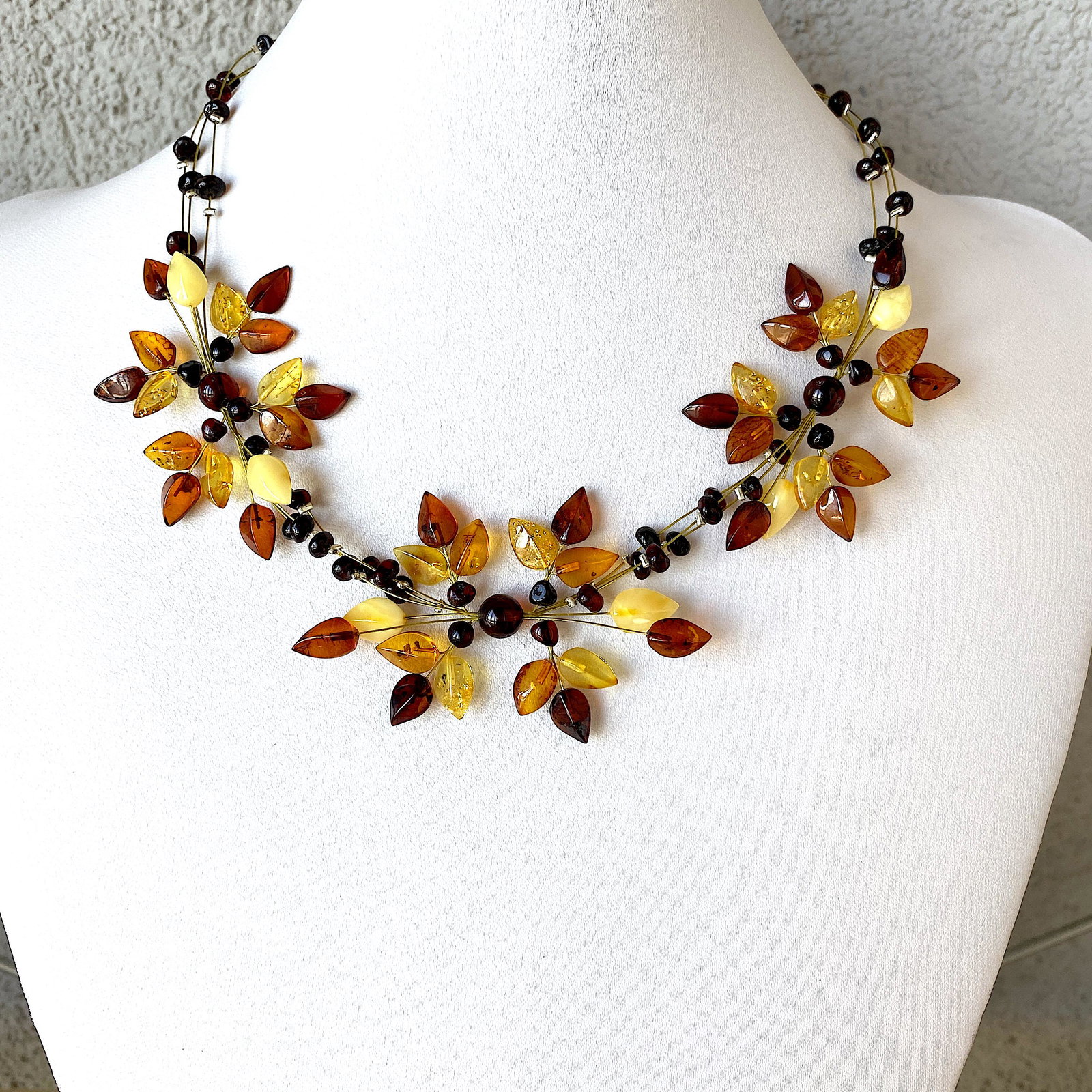 Phenomenal Amber Floral Necklace made from leaf like bead ornaments: Title: Phenomenal Amber Floral Necklace made from leaf like bead ornaments Metal: None Gemstones: Amber Weight: 12.0 g Size: Size: 73.0 x 420.0 x 10.0 mm Size: 2.874 x 16.535 x 0.394 inches Made of: W