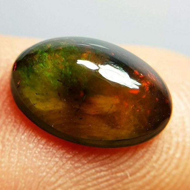 3.30 ctz " Play Of Colors" Natural Black Opal: No Reserve! Title:3.30 ctz " Play Of Colors" Natural Black Opal Color/Clarity:Play of Colors / VVS Gemstones:Opal Carat Weights:3.3 Size/Dimensions:12.60 x 9.00 x 5.50 Additional Information:Oval / Et