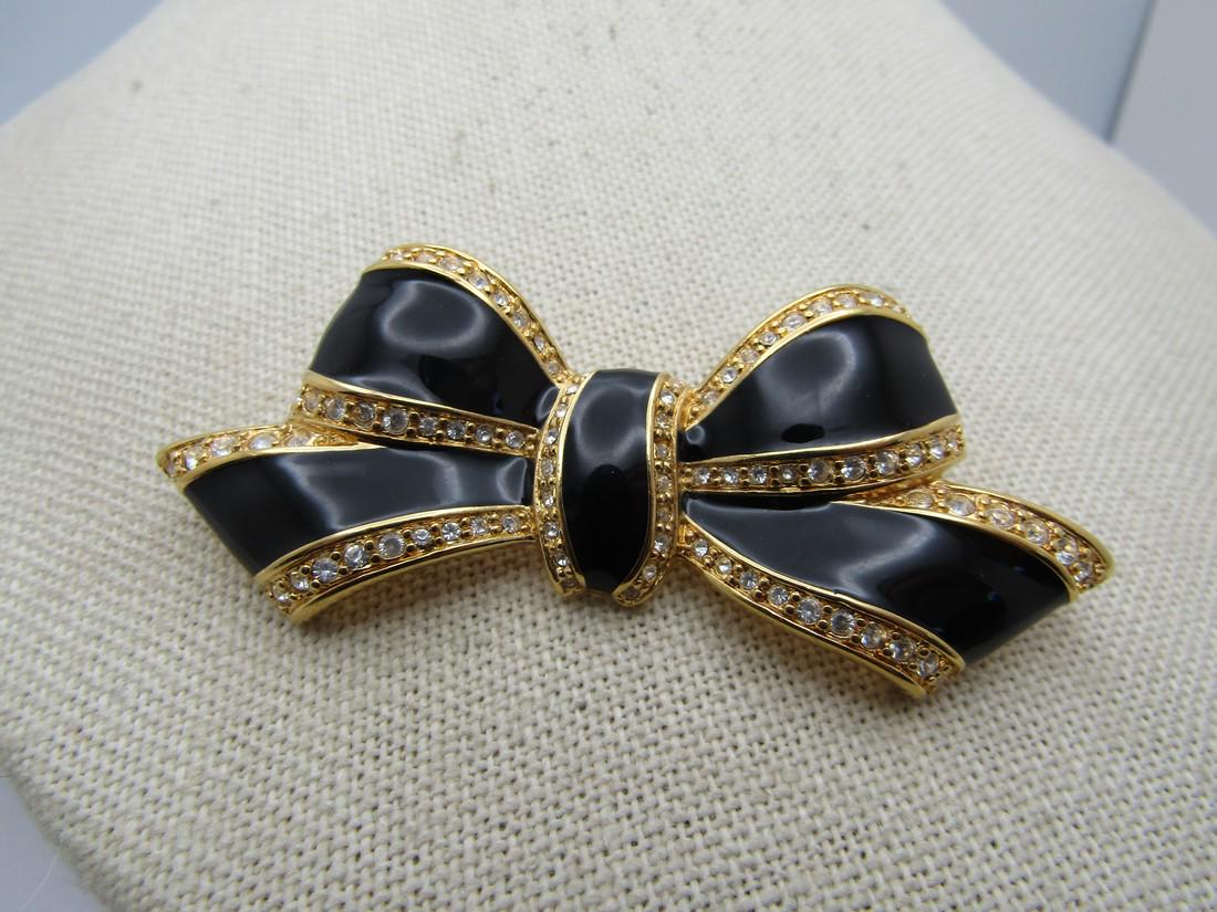 Vintage Napier Black Bow & Rhinestone Brooch, 1980's-1990's: Vintage Napier Black Bow & Rhinestone Brooch, 1980's-1990's. 2.75" wide nd 1.25" tall. Nickely looped bow with gold tone metal and black enameling and edges with clear rhinestones. Signed Napier. Age 