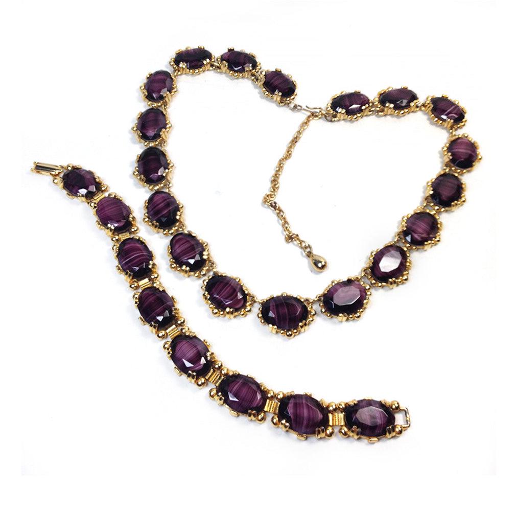 Purple Porphyry Glass Set: 1960's gold tone hook-clasp adjustable necklace and fold-over clasp bracelet with purple faceted porphyry glass stones. Dimensions: necklace adjustable 16.5-21 inch; bracelet 8 x 0.75 x 0.25 Reserve: 