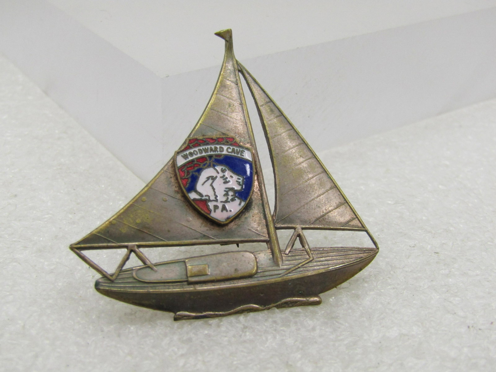 Vintage Enameled Woodward Cave Sail Boat Brooch, 2": Vintage Enameled Woodward Cave Sail Boat Brooch, 2" by 1.75" wide. This has an enameled shield in red, white, and blue with the wording Woodward Cave PA on the larger sail. The cave is known for its b