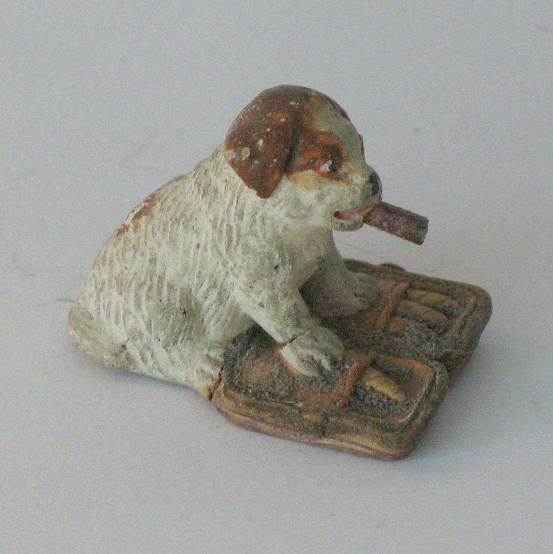 Antique bisque puppy stole a pouch of cigars.: Title: Antique bisque puppy stole a pouch of cigars. Date/Period: 1920's Dimension: 1” x 1 1/2” Additional Information: Nice whimsical bisque puppy who stole a pouch of cigars and wanted a