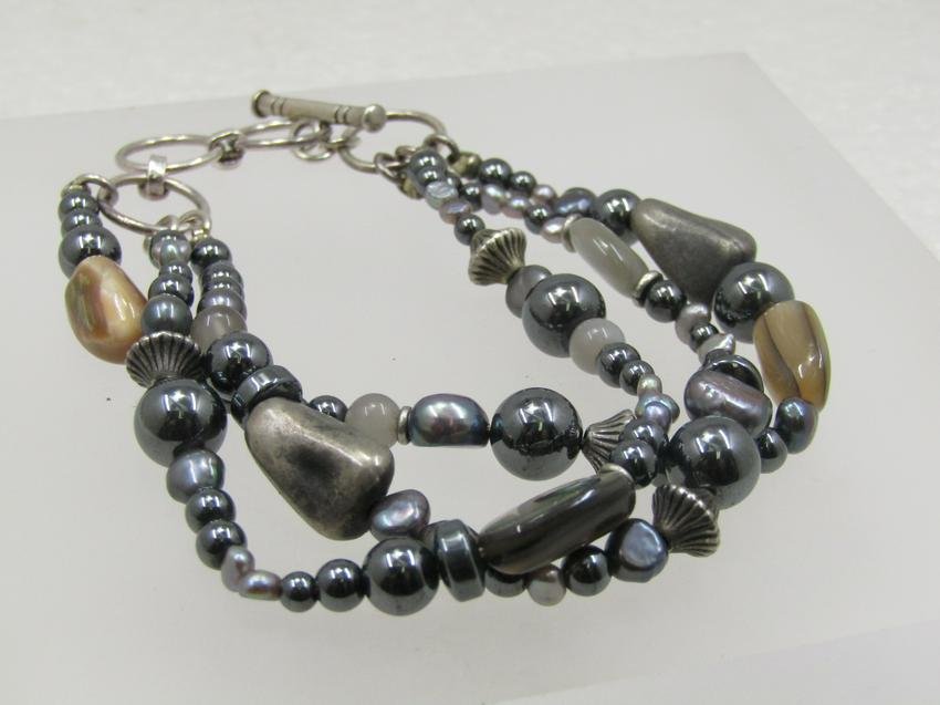 Sterling Triple Strand Polished Stone Bracelet, Toggle Clasp, 8.5", Adj.: DescriptionSterling Triple Strand Polished Stone Bracelet, Toggle Clasp, 8.5", Adj. Mother-of-Pearl, Abalone, Magnetite, Glass, and Moonstone beads from 3mm to 7.5mm in a mix of round and natural shap