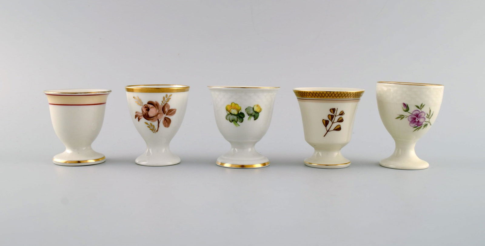 Royal Copenhagen and Bing & Grøndahl. Five egg cups in hand-painted porcelain. 1920s / 30s.: Royal Copenhagen and Bing & Grøndahl. Five egg cups in hand-painted porcelain. 1920s / 30s. Largest measures: 6.7 x 5.2 cm. In excellent condition. Stamped. 1st factory quality. Reserve: $140.00