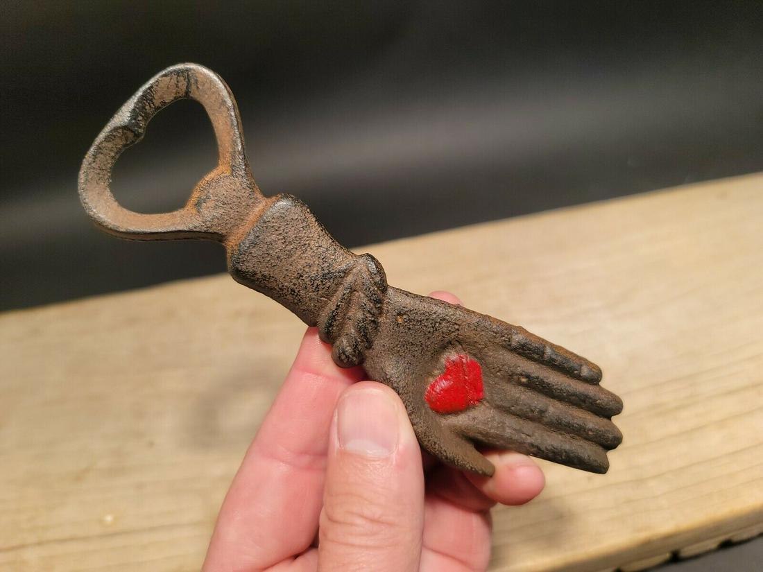 Cast Iron Heart in Hand Odd Fellows Bottle Opener: 5 3/4" long x 1 1/2" Wide A wonderful reproduction cast iron heart in palm bottle opener. Many times the symbol of a heart in an open palm is symbolic of an open welcome or charity. It has also been t