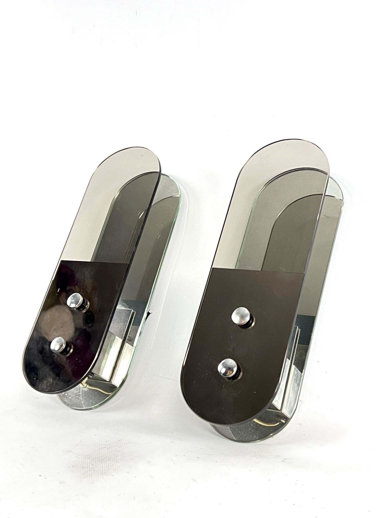 Italian Mid-Century set of two wall mirror lamps by Veca. 1970s: Good vintage condition with normal trace of age and use for this pair of sconces produced by Veca during the 70s and made from mirror, glass and metal. No chips or cracks but a small chip in the inter