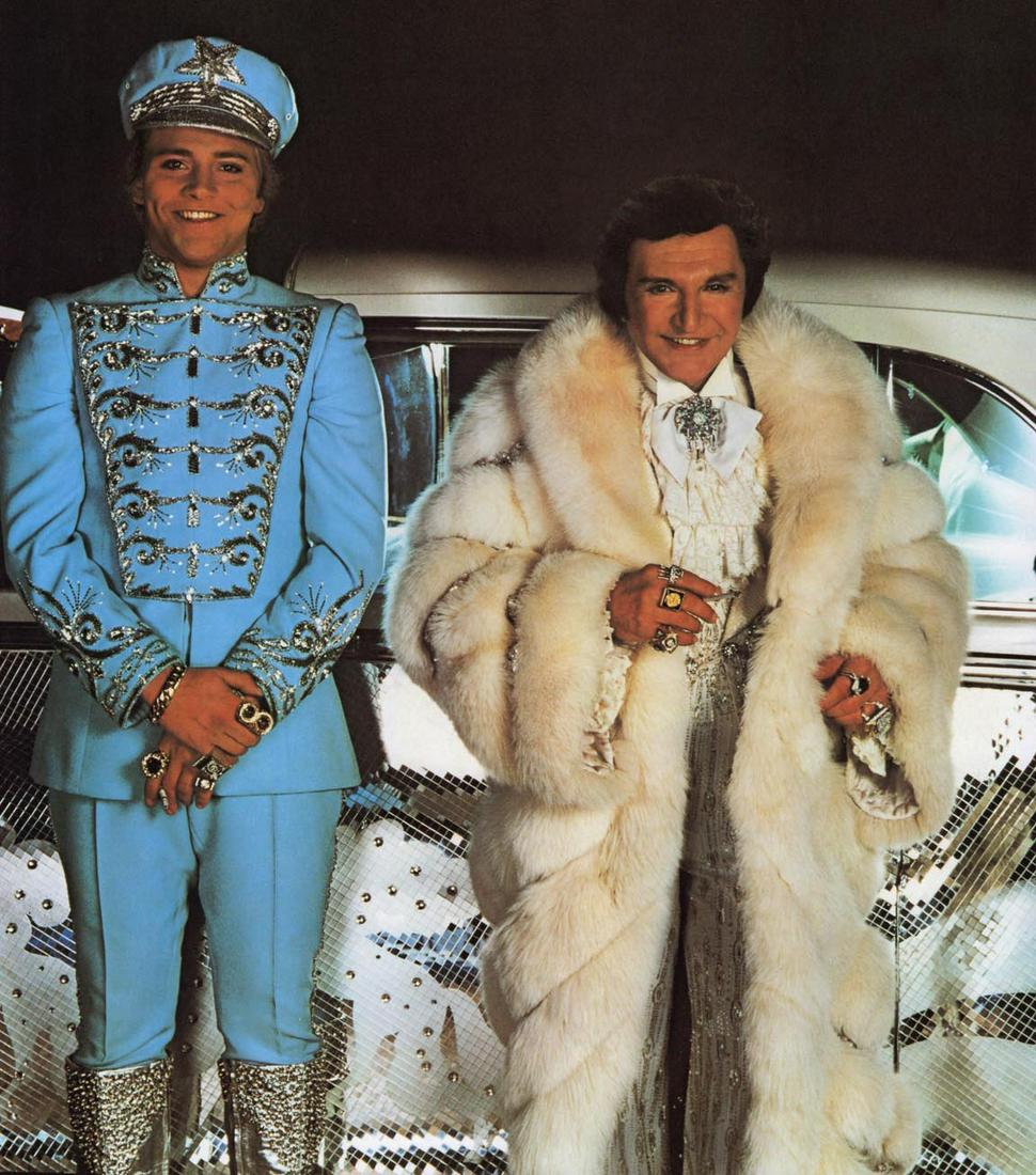 ANNIE LEIBOVITZ - Liberace and Scott Thorson, Las Vegas, 1981: Artist: ANNIE LEIBOVITZ Print Title: Liberace and Scott Thorson, Las Vegas, 1981 Medium: Photo-lithograph Printed 1990s in Italy Image size (inches) approx. 11 x 9” Additional Information: COAS 