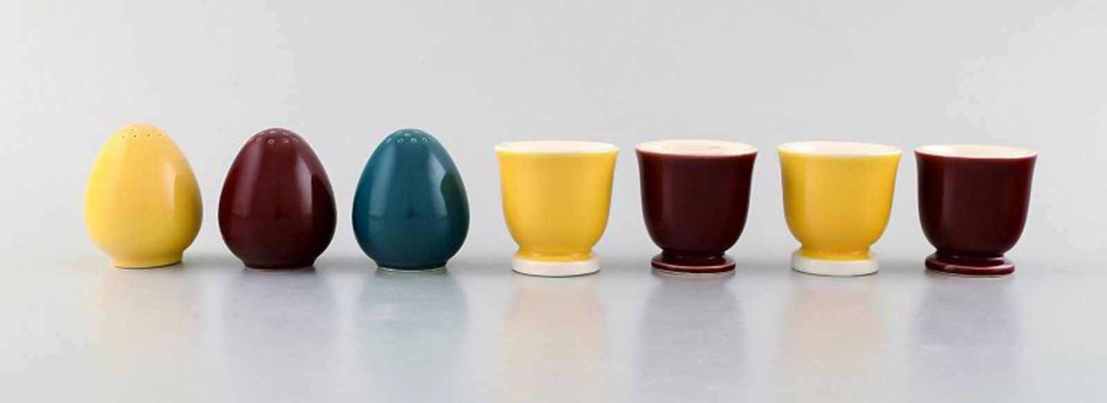 Confetti Royal Copenhagen / Aluminum faience. Three salt shakers and four egg cups in glazed: Confetti Royal Copenhagen / Aluminum faience. Three salt shakers and four egg cups in glazed faience. Bordeaux, yellow and turquoise glaze. The salt shaker measures: 5.5 x 5 cm. The egg cup measures: