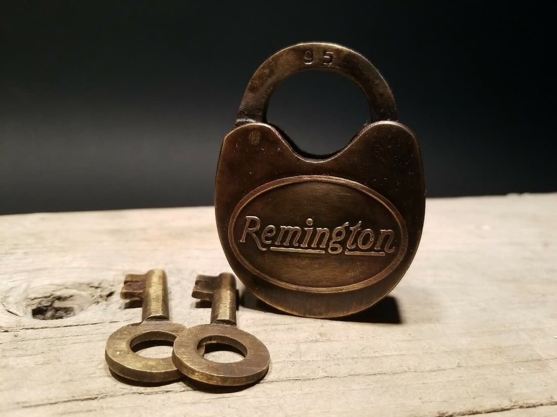 Cast Iron Remington Firearms Ammo Box Padlock Lock & Key: 3" tall x 2" Wide the shank is 3/8" at its thickest Nice reproduction cast iron Remington padlock! This lock is fully functional! Hard to tell its age. Heavy iron and brass. Great aged patina througho