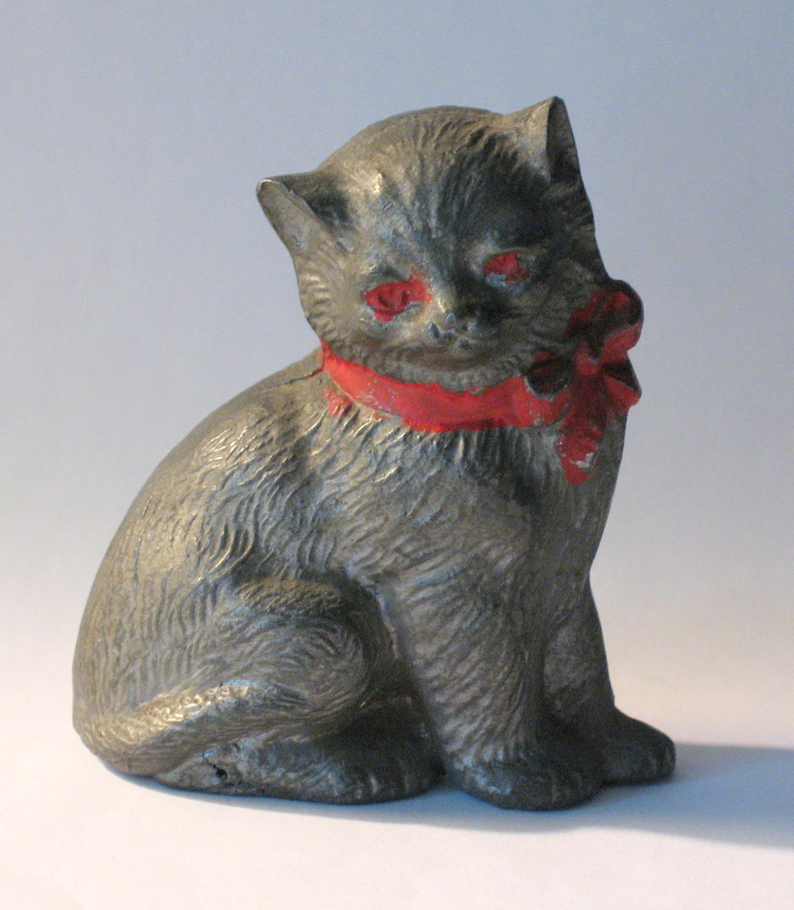 Vintage cast metal cat with red bow paper weight. (1 of 3)