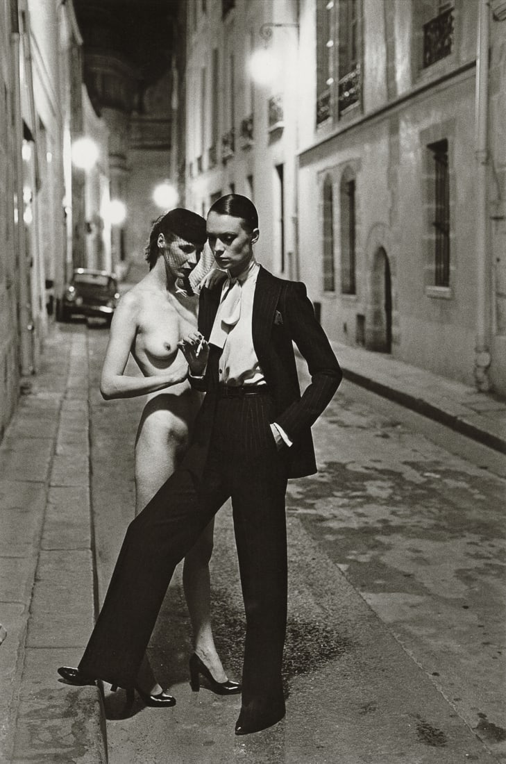 HELMUT NEWTON - Le Smoking, YSL, Rue Aubriot, Paris: Artist: Helmut Newton Title: Le Smoking, YSL, Rue Aubriot, Paris, 1975 Medium: Photo Litho, 2017, China Dimensions: 6.9x10.4" Description: Heat Wax Mounted on 11x14" Conservation Board Artist Bio: Hel