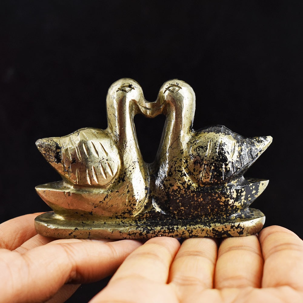 Beautiful 750.00 Carats Genuine Pyrite Hand Carved Crystal Swan Pair Gemstone Carving: Turn heads with this exquisite 750-carat crystal swan pair! Hand-carved from genuine pyrite, this twosome will put the "swan" in swoon-worthy décor. Let their graceful beauty take flight in your