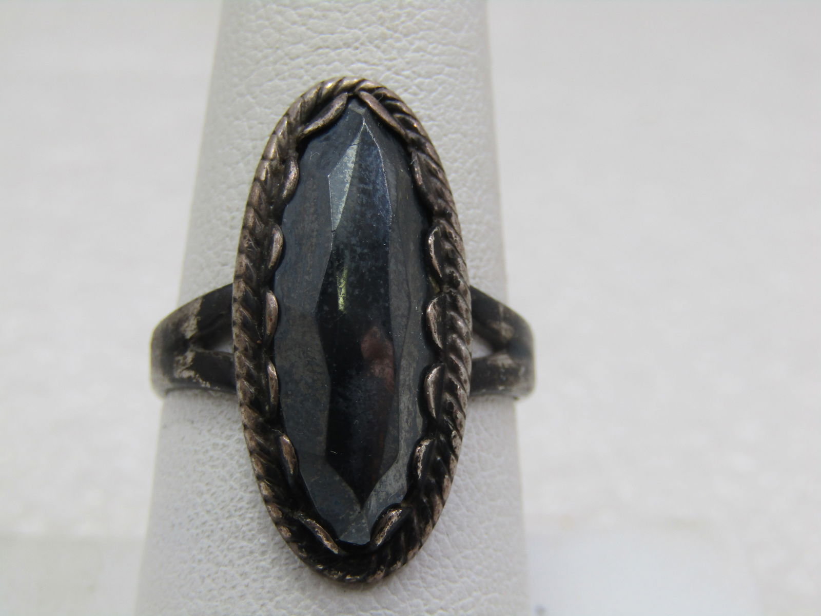 Vintage Sterling Hematite Long Ring, Sz. 8.5 , 1940's-1950's Bell Trading: Vintage Sterling Hematite Long Ring, Sz. 8.5 , 1940's-1950's. Scalloped bezel settign that holds the faceted high-top stone that is appx. 21mm by 9mm. Marked sterling and tested. weight is appx. 5.87