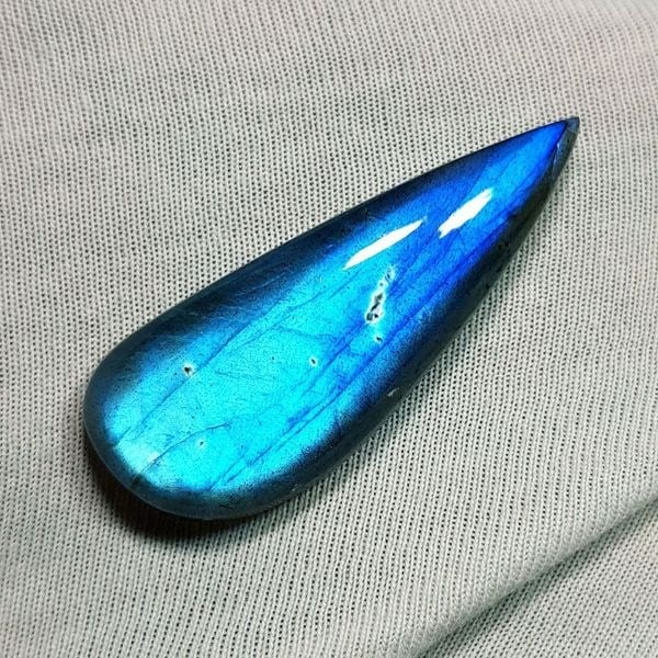 36.08 Ctz Natural Blue Labradorite: No Reserve! Title: 36.08 Ctz Natural Blue Labradorite Color/Clarity: Bluish / Semi Transparent Gemstone: Labradorite Carat Weights: 36.08 Size: 39.50 x 15.00 x 7.90 Additional Information: Fancy Caboc