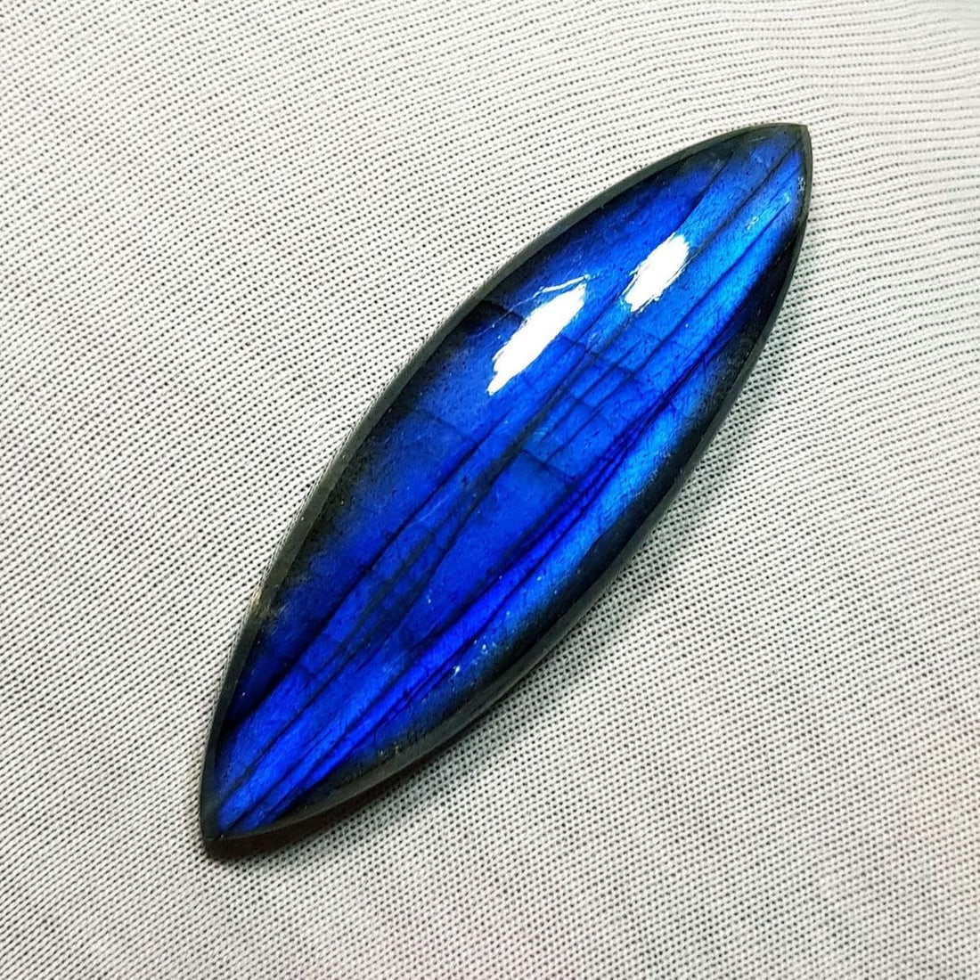 52.38 Ctz Natural Blue Labradorite: No Reserve! Title: 52.38 Ctz Natural Blue Labradorite Color/Clarity: Bluish / Semi Transparent Gemstone: Labradorite Carat Weights: 52.38 Size: 52.90 x 16.90 x 7.40 Additional Information: Maquise Cab