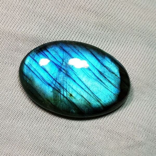 40.50 Ctz Natural Blue Labradorite: No Reserve! Title: 40.50 Ctz Natural Blue Labradorite Color/Clarity: Bluish / Semi Transparent Gemstone: Labradorite Carat Weights: 40.5 Size: 32.30 x 21.60 x 7.00 Additional Information: Oval Cabocho