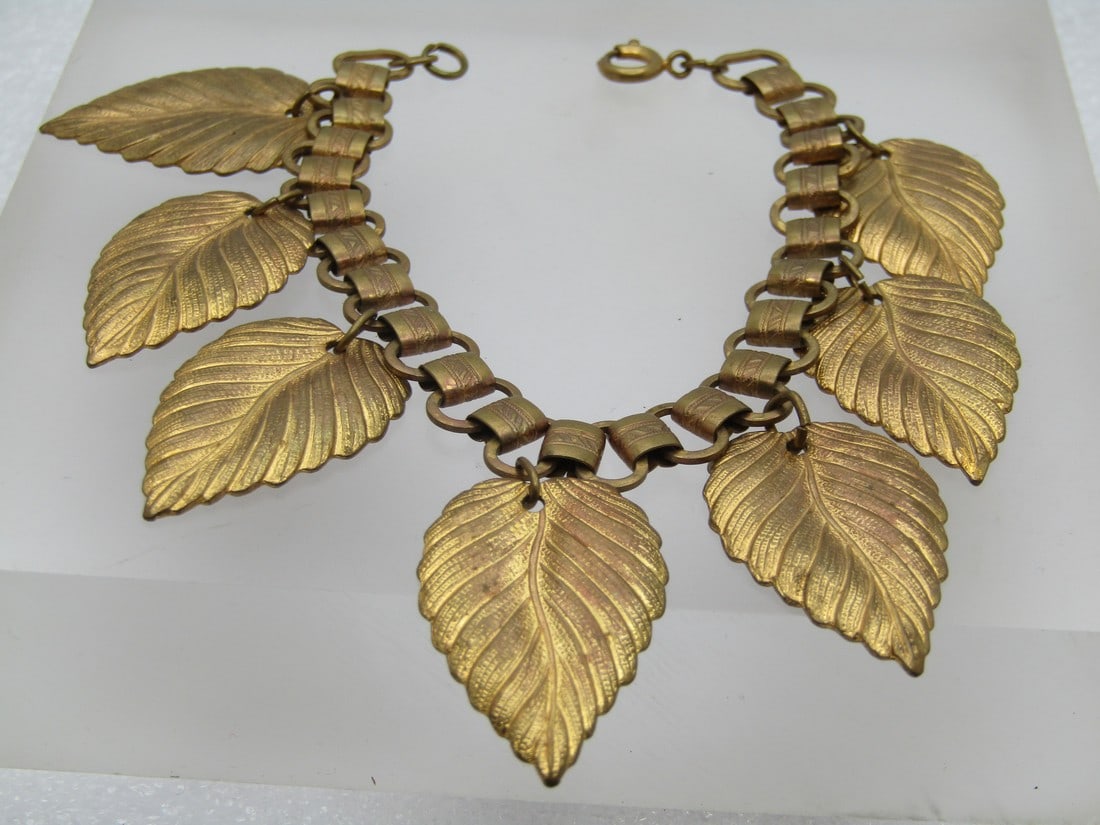 Vintage Gold Tone Leaf Charm Bracelet, 1930's-1940's , 6.75": Vintage Gold Tone Leaf Charm Bracelet, 1930's-1940's , 6.75". Seven 1.25" long textured detailed leaves that are appx. 3/4" wide dangle like charms from a charm bracelet. The bracelet has oval links t