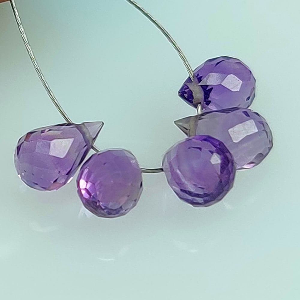 3.80 Ctw Natural 5 Drilled Purple Amethyst Pear Drop Beads: No Reserve! Title: 3.80 Ctw Natural 5 Drilled Purple Amethyst Pear Drop Beads Stone Clarity: Transparent Gemstones: Natural Amethyst Beads Carat Weights: 3.8 Size/Dimensions: 6.9x3.1- 7.2x3.2 mm / 5 P
