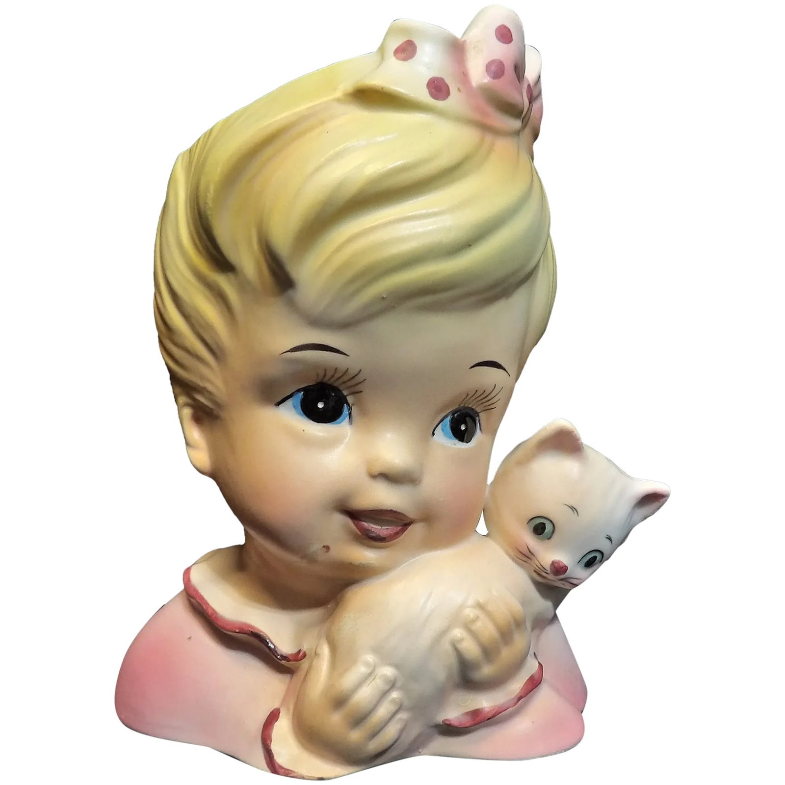Enesco Young Girl with Kitten Head Vase: This Enesco Young Girl with Kitten Head Vase is in excellent condition. It measures 5 ½” tall 4 ¼” wide and 2 ¾” deep. She has a pink dress and bow with polka dots. No