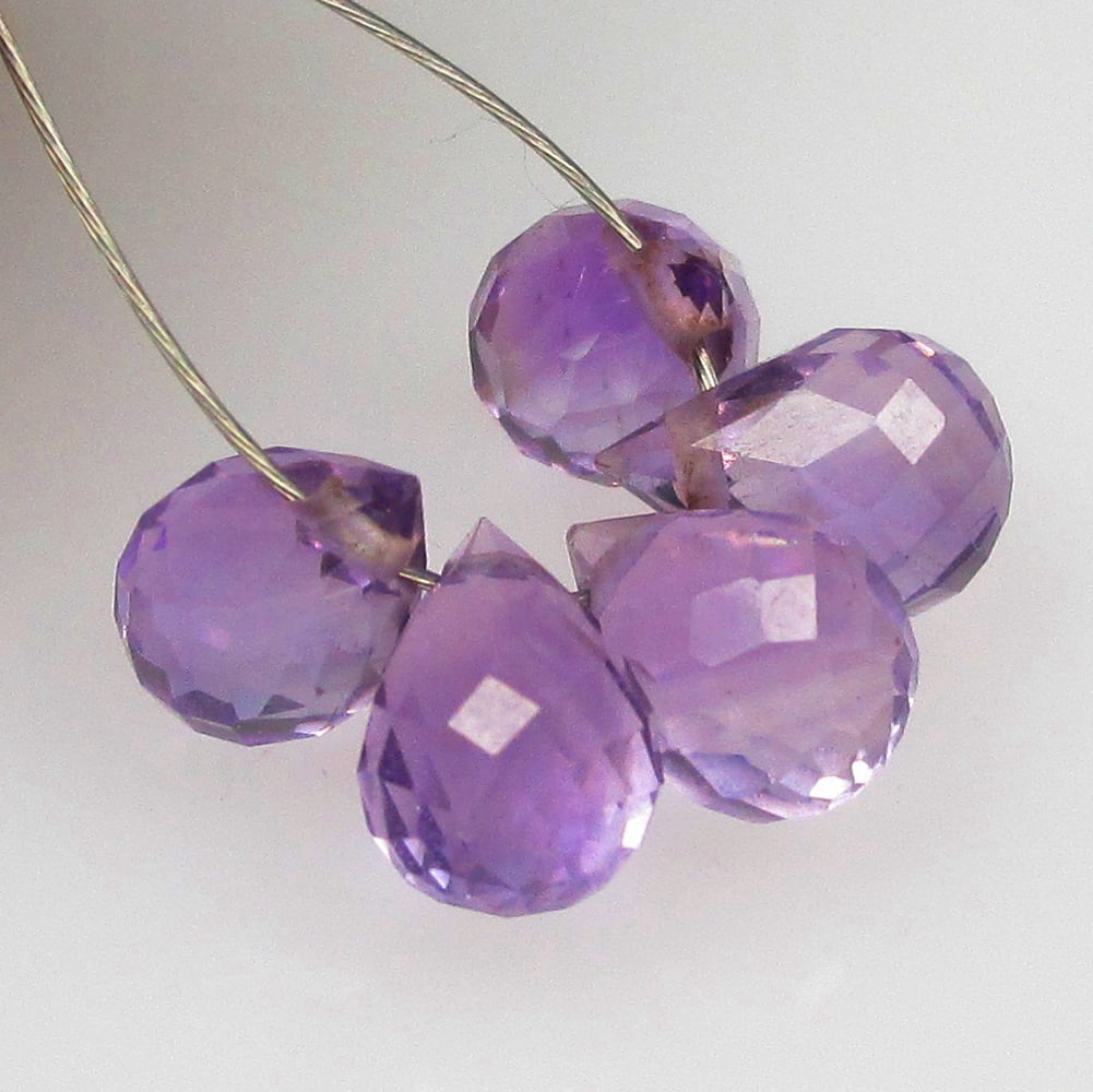 3.89 Ctw Natural 5 Drilled Purple Amethyst Pear Drop Beads: No Reserve! Title: 3.89 Ctw Natural 5 Drilled Purple Amethyst Pear Drop Beads Stone Clarity: Transparent Gemstones: Natural Amethyst Beads Carat Weights: 3.89 Size/Dimensions: 6.6x3.1 - 6.9x3.5 mm / 5