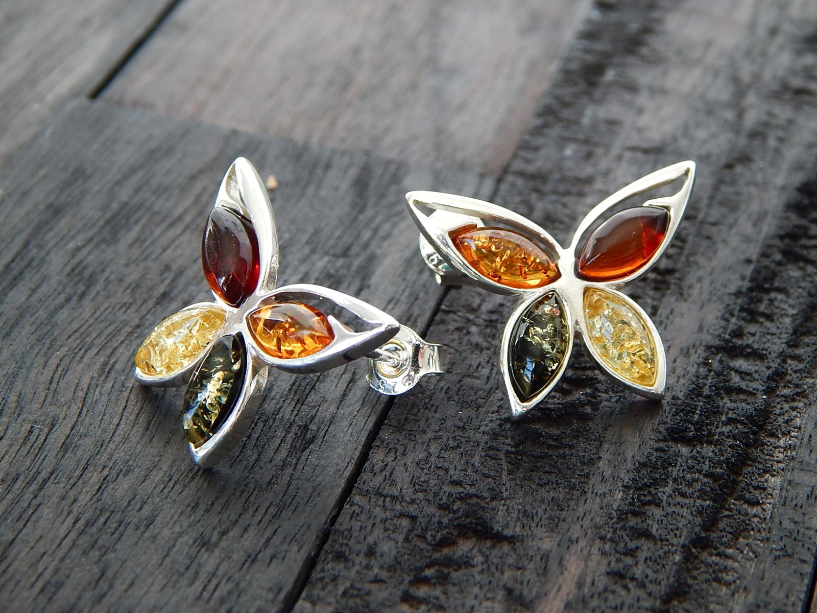 Natural Baltic Multicolor Amber Butterfly Earrings Studs: Title: Natural Baltic Multicolor Amber Butterfly Earrings Studs Additional Information: Handcrafted in Poland, these Natural Baltic Multicolor Amber Butterfly Earring Studs boast a vivid blend of cher