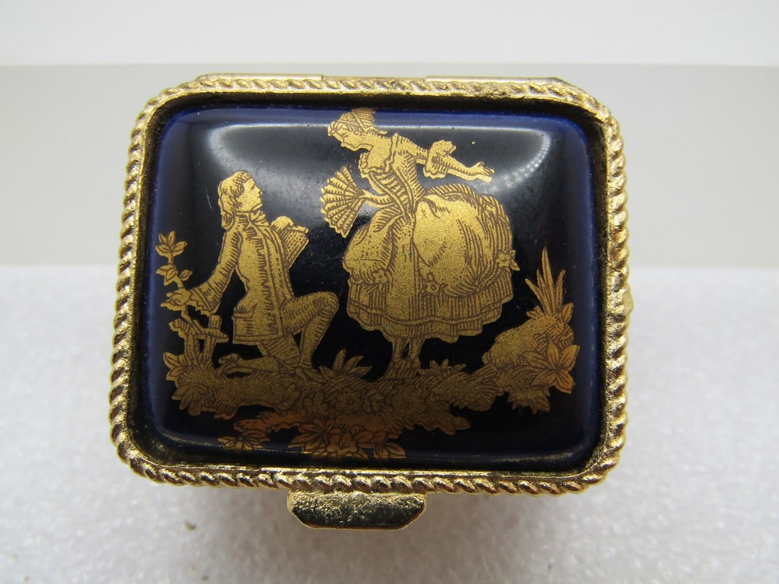 Vintage Courting Scene Pill Box, 1960's-1970's: Vintage Courting Scene Pill Box, 1960's-1970's. Dark blue background, slightly domed from the edges with a gold French courting scene in gold. It is rectangular a appx. 1.25" wide and 1-1.8" front-to-