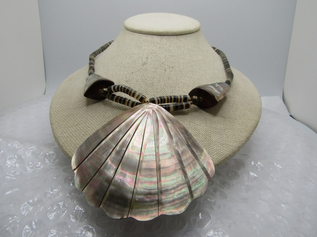 Vintage Tan Seashell Heishi Necklace, 21.5", Tan Mother-of-Pearl: Vintage Tan Seashell Heishi Necklace, 21.5", Tan Mother-of-Pearl. This has a scalloped shell necklace with carved lines. The shell pendant portion is appx.2.75" long and 3" wide. It is strung on a dou