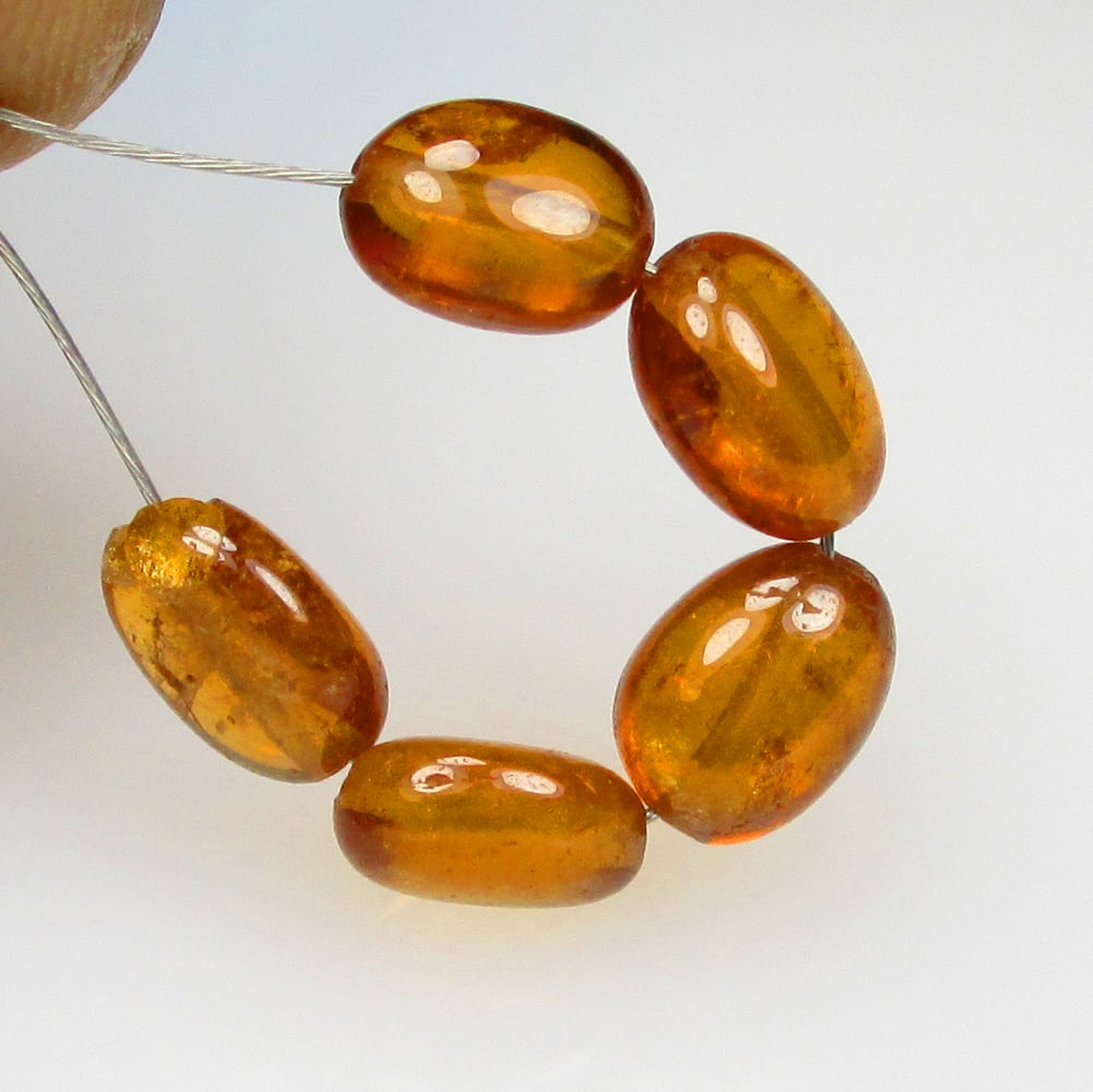 5.83 Ctw Natural 5 Hessonite Garnet Dumble Beads: No Reserve! Title: 5.83 Ctw Natural 5 Hessonite Garnet Dumble Beads Stone Clarity: Transparent Gemstones: Natural Hessonite Garnet Beads Carat Weights: 5.83 Size/Dimensions: 4.7x3.2 - 5.1x3.5 mm / 5 P